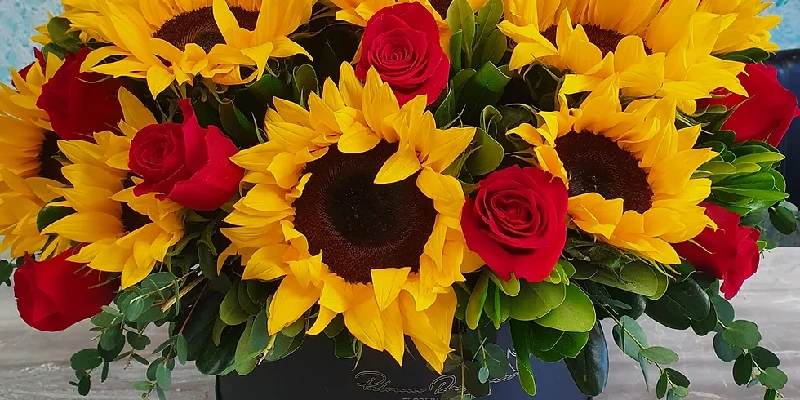 caja redonda con rosas y girasoles