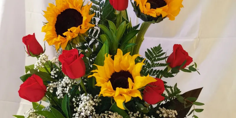 caja de girasoles, rosas rojas y nubecitas 