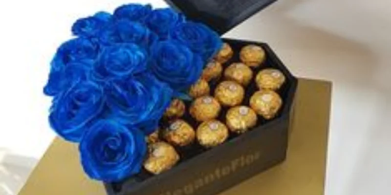 rosas azules y chocolates en caja de corazón 