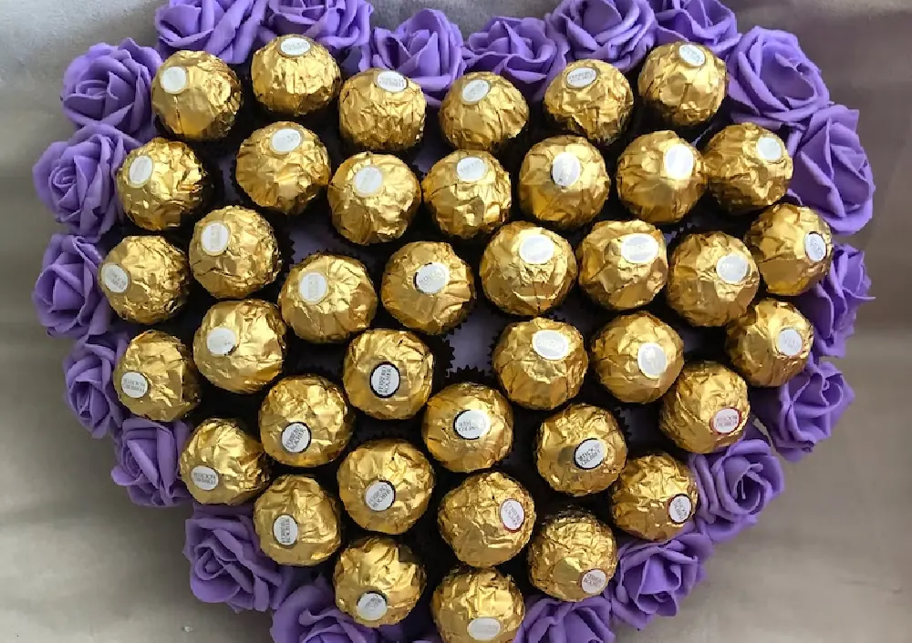 heart box of ferrero chocolates with purple roses