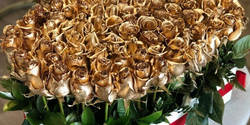 rosas doradas dentro de una caja de corazon